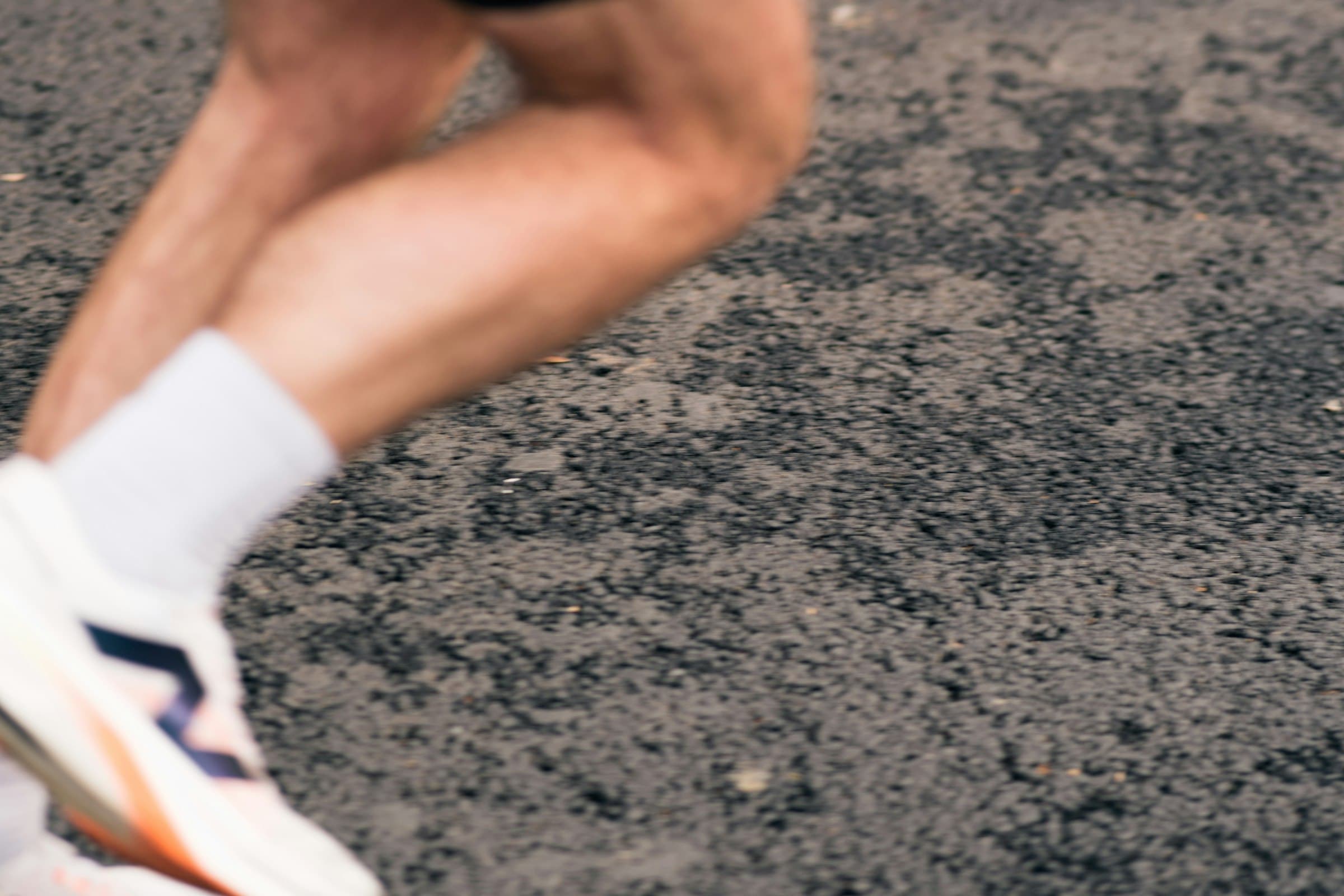A runner's legs in motion on pavement