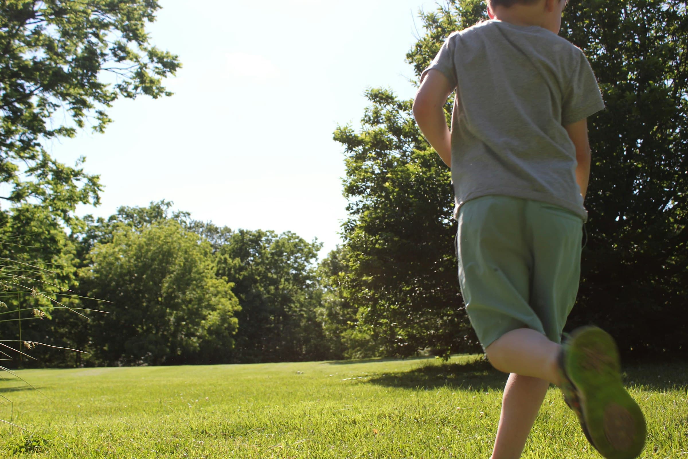 A child running across a sunlit field